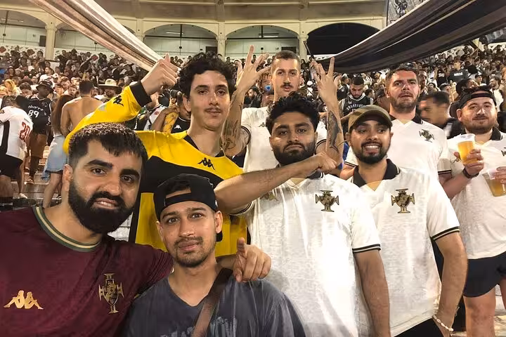 Group of Vasco da Gama supporters in club shirts cheering inside São Januário stadium, Rio de Janeiro guided match tour