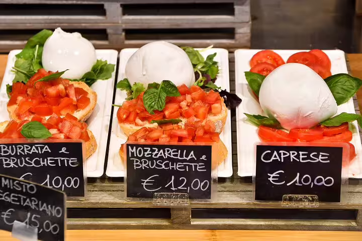 Fresh Italian bruschetta and caprese with mozzarella displayed at Vatican Market Experience, highlighting authentic culinary delights.