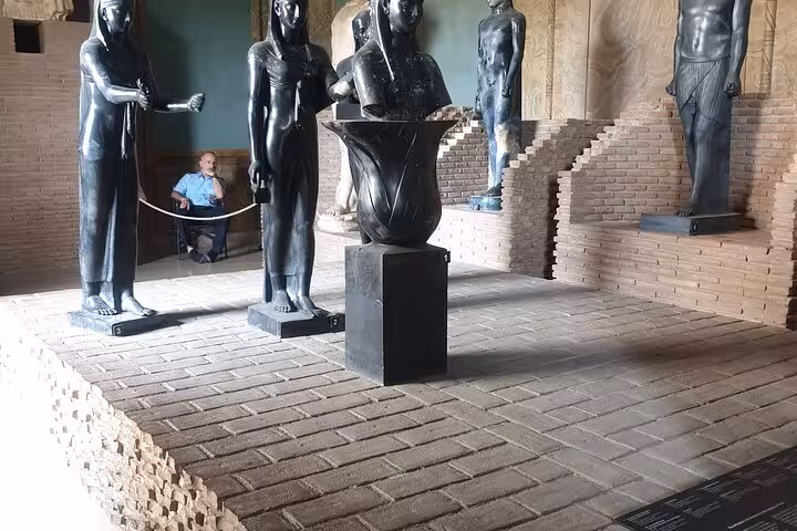 Ancient statues displayed in a Vatican Museum exhibit room during a guided tour.