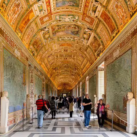 Tourists walk through the ornate Gallery of Maps on a Vatican Museums and Sistine Chapel guided group tour in Rome