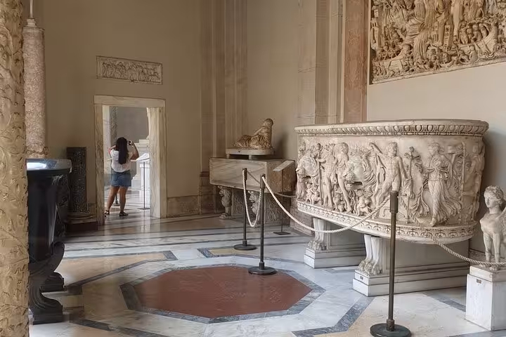 Intricate sculptures and artifacts on display in Vatican Museum room, showcasing art on a private guided tour.