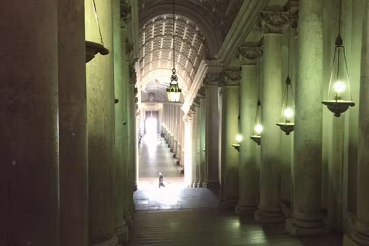 Vatican Museums corridor with columns and hanging lamps, part of skip-the-line hosted entry with audio guide