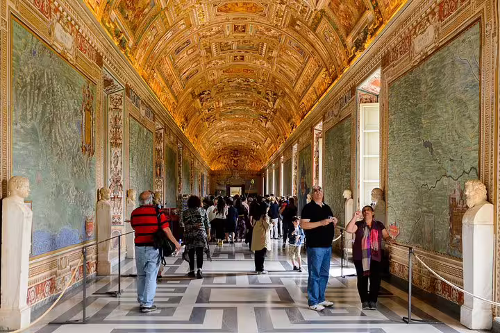 Visitors walking through the ornate Gallery of Maps in the Vatican Museums on a guided Rome in 2 Days Colosseum and Vatican tour