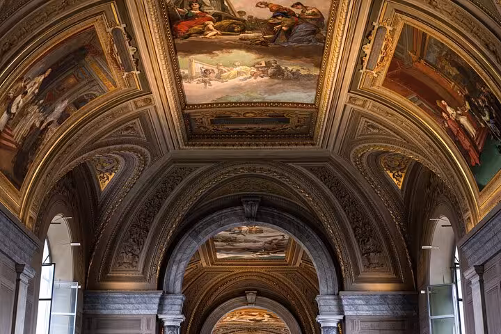 Ornate Vatican Museums gallery ceiling frescoes and arches seen on skip-the-line hosted entry official audio tour