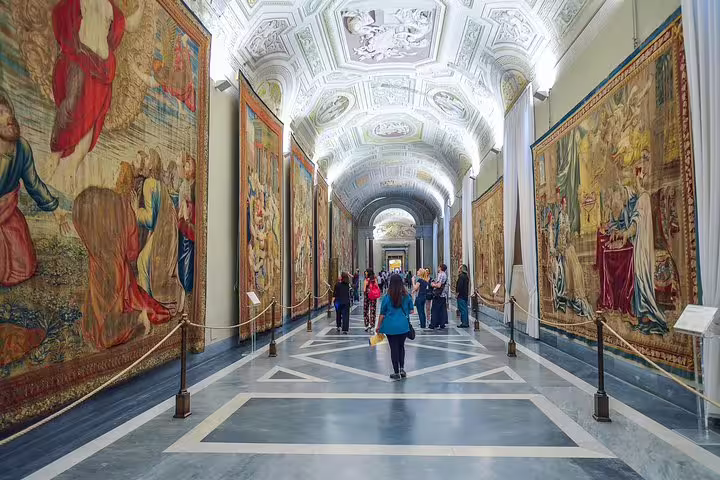 Tourists exploring the Vatican Museums tapestry gallery on a Rome in 2 Days Colosseum, Vatican and catacombs skip-the-line tour