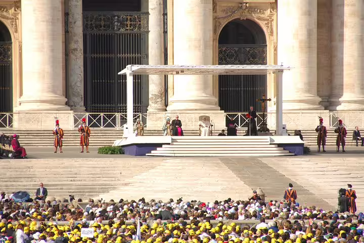 Crowds gathered in St Peter’s Square for Vatican Papal Audience with view of stage, Swiss Guards and basilica on guided tour