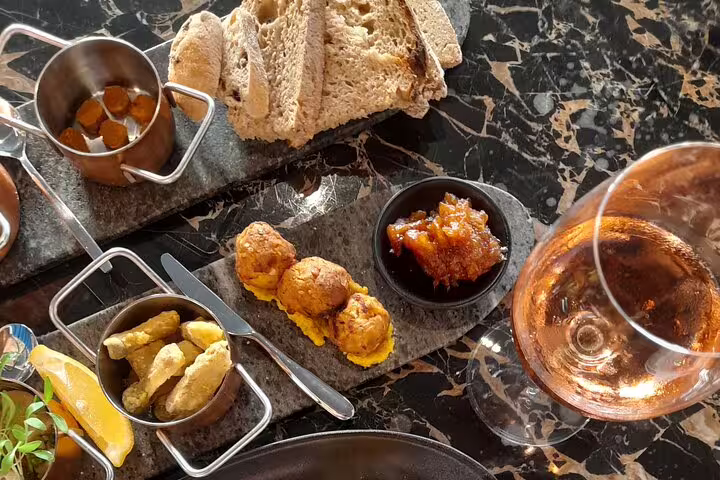 Elegant vegan tapas with bread, vegetables, and wine, showcasing a delicious culinary walking tour.