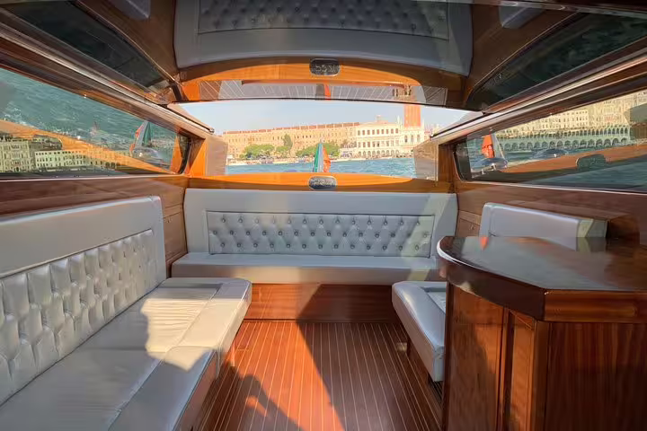 Luxurious interior of a Venetian water taxi with panoramic views on the Venice deluxe heritage tour.