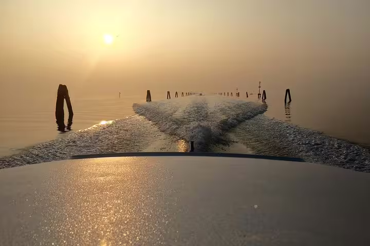 Private water taxi transfer from Venice Marco Polo Airport to city center hotel at sunrise on lagoon