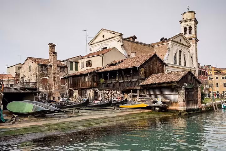 Historic shipyard along Venice's canal, showcasing traditional gondola craftsmanship on the Canal Grande tour.