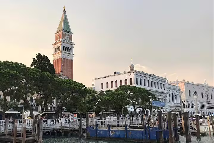 Stunning sunset view of Venice's iconic bell tower and waterfront, perfect for a Canal Grande boat trip experience.