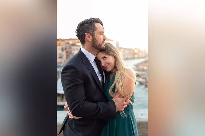 Romantic Venice city portrait session with couple embracing by the Grand Canal at golden hour