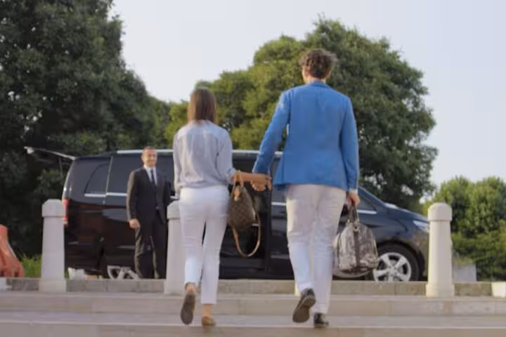 Couple approaching luxury transfer vehicle for Venice to Fusina Cruise Terminal service.