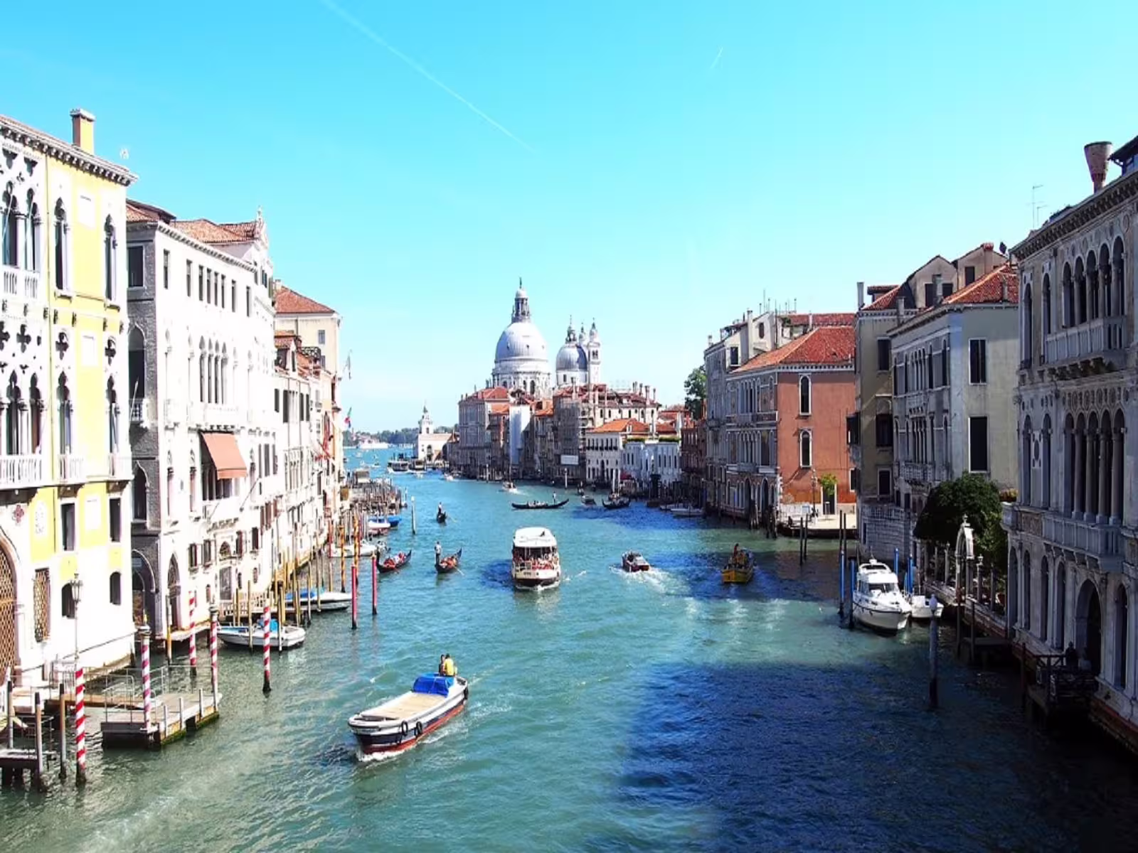 Boats and gondolas cruising the Grand Canal towards Santa Maria della Salute, seen during a 3 hours Venice walking tour