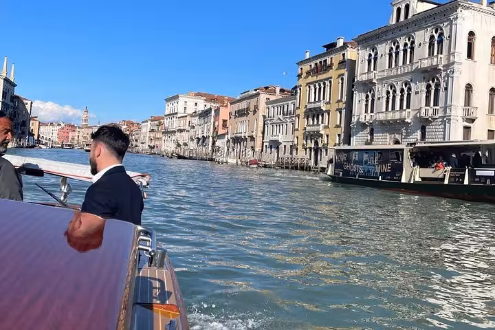Private boat gliding through Venice's scenic Grand Canal with historic architecture in view, ideal for Marco Polo Airport transfers.