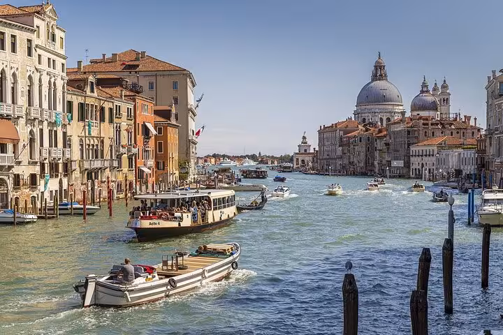 Discover Venice's iconic Grand Canal with bustling boats and stunning architecture on a day trip from Florence.