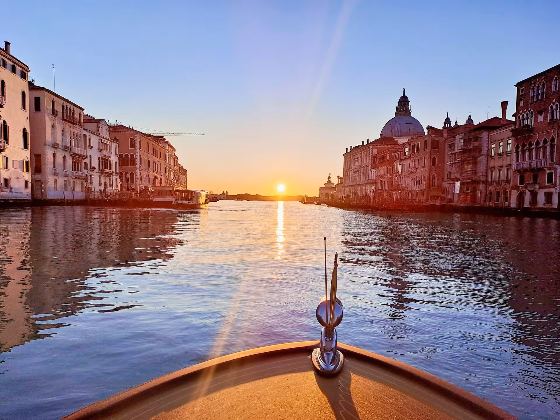 Scenic view of Venice's Grand Canal at sunset from a boat, perfect for transfers to Rialto Bridge or St Mark's Square.