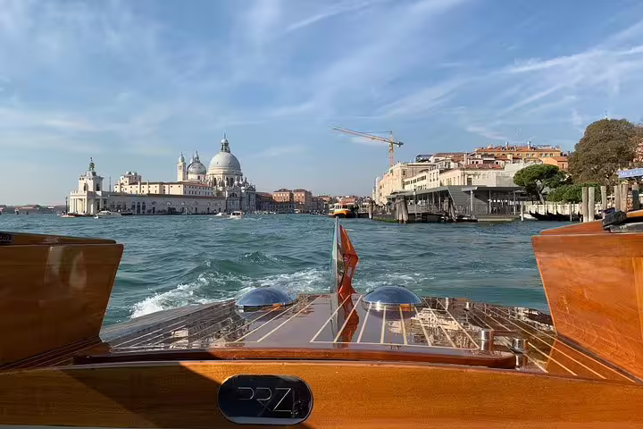 Private wooden boat cruising Venice Grand Canal toward Santa Maria della Salute on Murano Burano tour