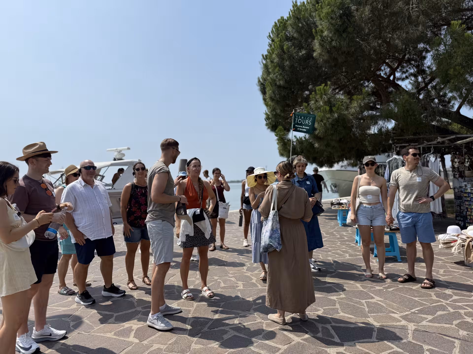 Tour group gathers under a tree during the Grand Tour of Venice, preparing for a Murano and Burano exploration.