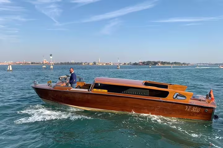 Classic wooden boat cruising through Venice's scenic waters, ideal for a Murano boat tour experience.