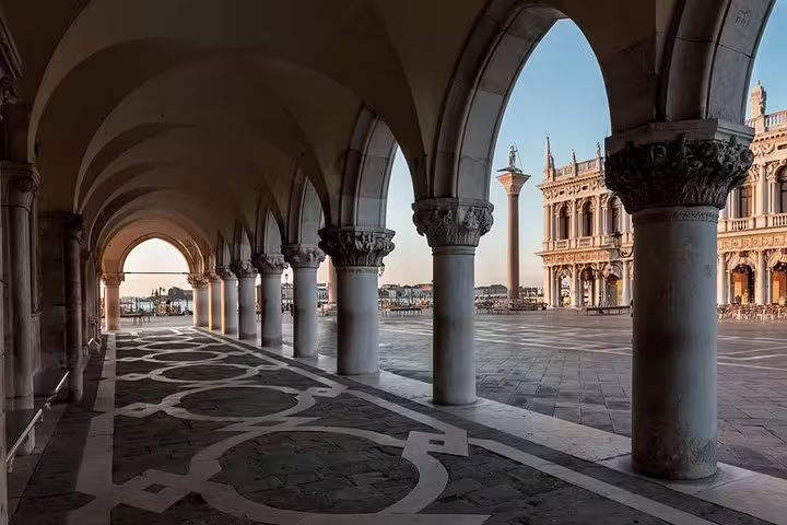 Scenic view of St. Mark's Square and its iconic arches in Venice, capturing historic Venetian architecture and open plaza.