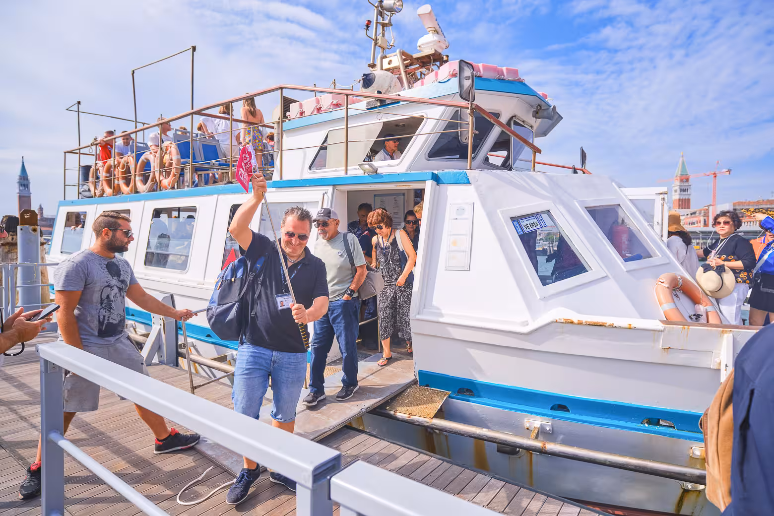 Visitors disembark from a tour boat in Venice, ready to explore the historic canals and iconic architecture.
