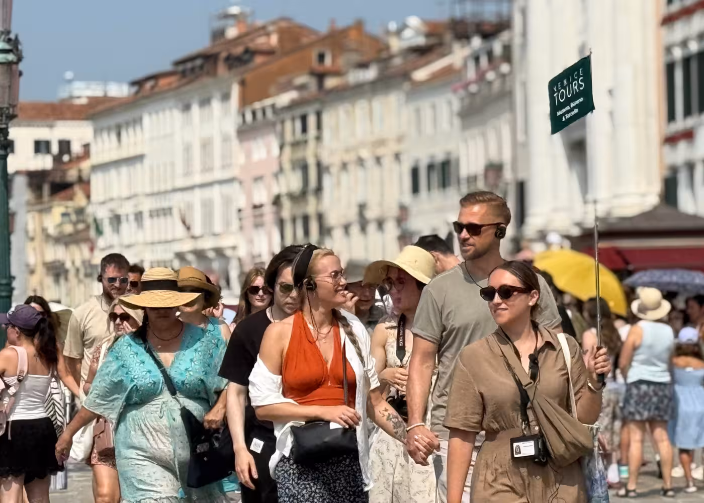 Tourists enjoy a guided walking tour in Venice, showcasing the vibrant streets and charming architecture.