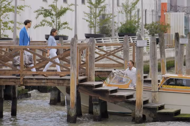 Travelers boarding a water taxi at Venice pier for Fusina Cruise Terminal transfer, emphasizing convenience and style.