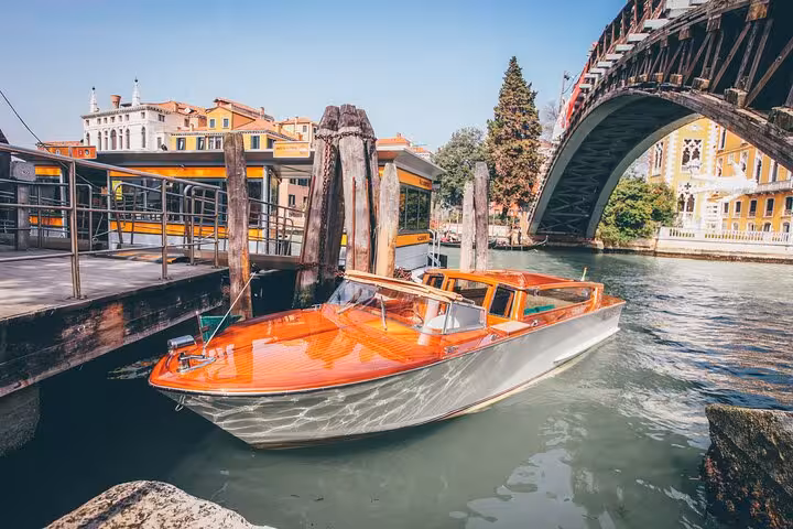 Elegant wooden water taxi docked in Venice, offering scenic private transfers to Trieste Port for cruise travelers.