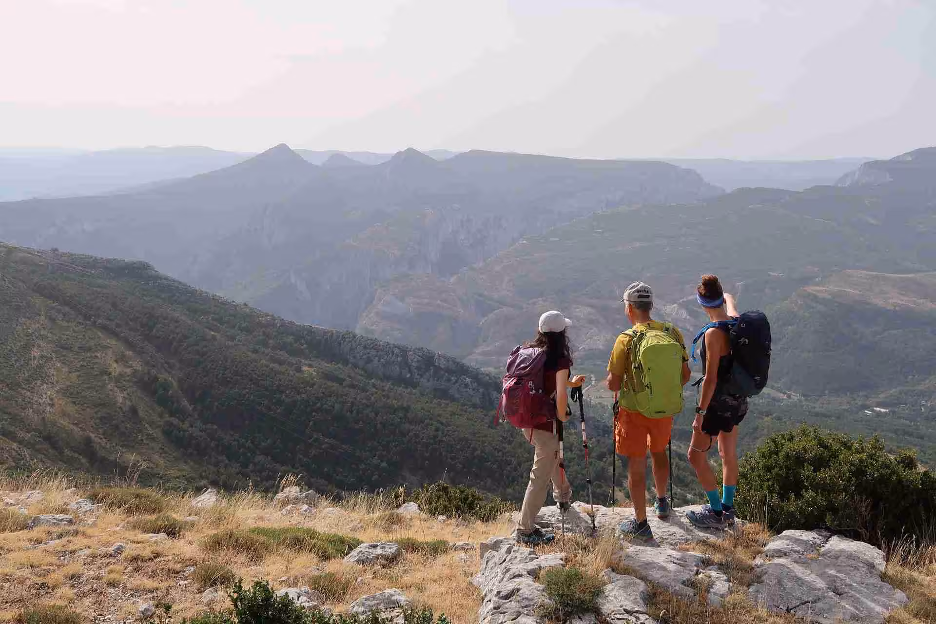 Three trekkers admire panoramic Verdon Gorge cliffs, part of the 6-day French Grand Canyon hiking trails