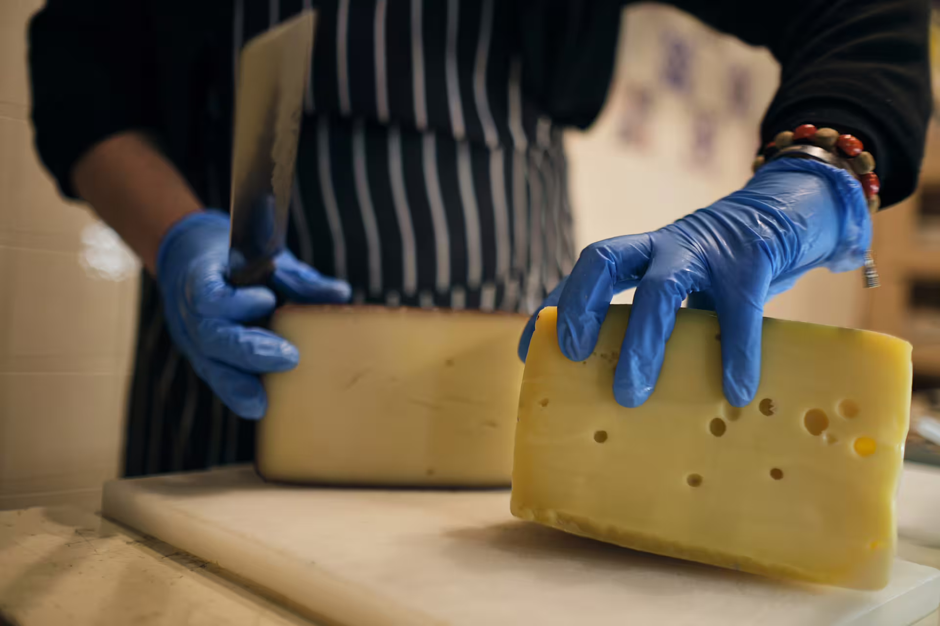 Cheesemonger cutting Italian cheese for tastings on a guided Verona food tour with local wine pairing