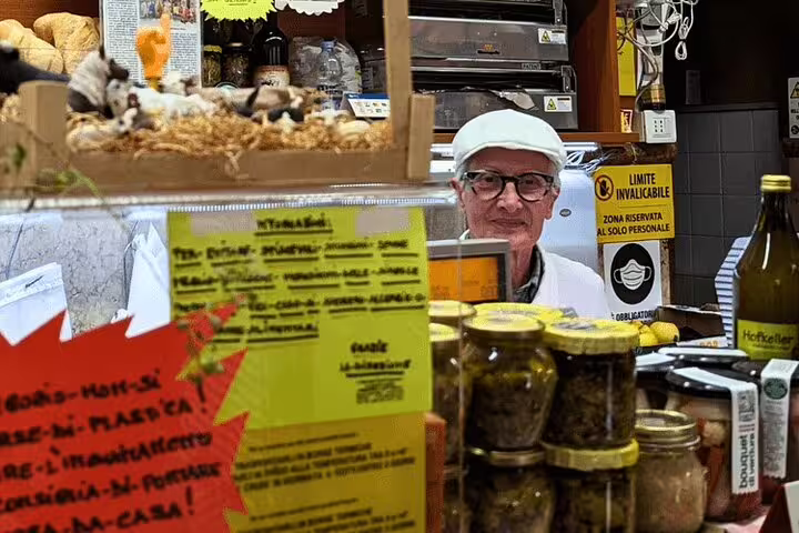 Verona market vendor with local delicacies on a 1.5 hour food tour, tastings and city sightseeing