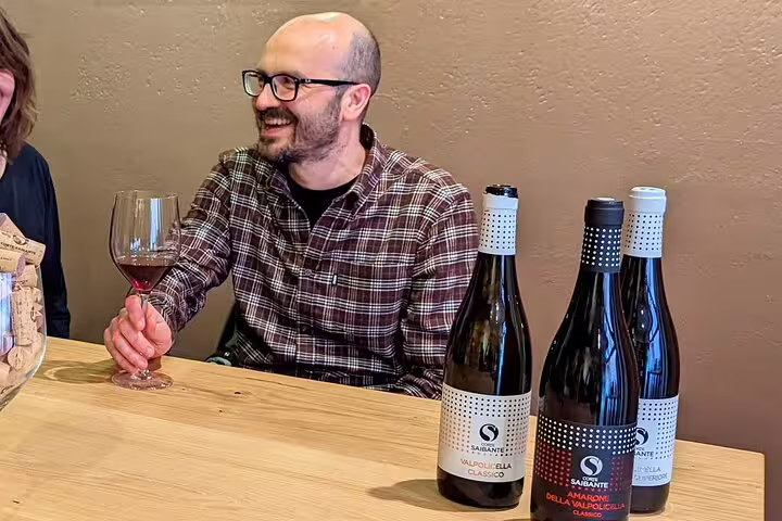 Traveler sampling Amarone and Valpolicella wines in Verona tasting room on guided food tour with wine pairings