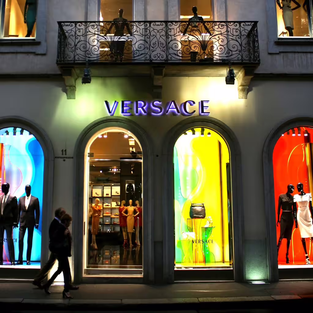 Illuminated Versace boutique with colorful window displays on Via Monte Napoleone in Milan’s upscale fashion district