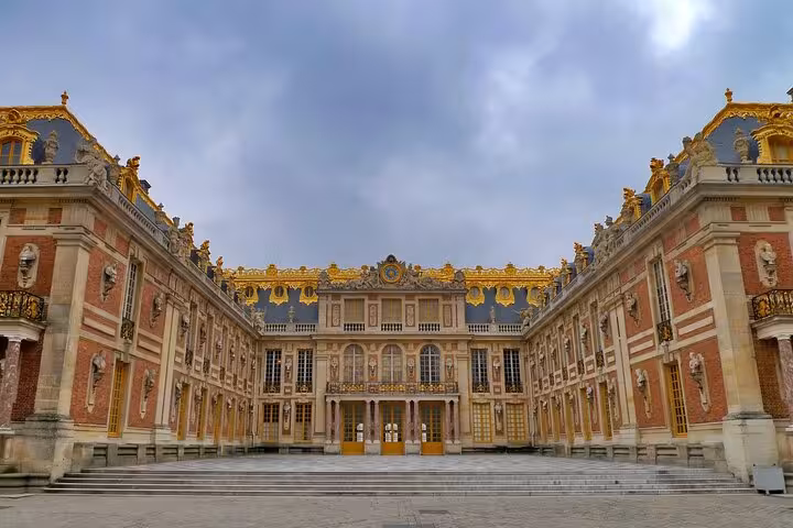 Versailles Grand Tour courtyard panorama showing the palace entrance, gilded trim, and grand stairway