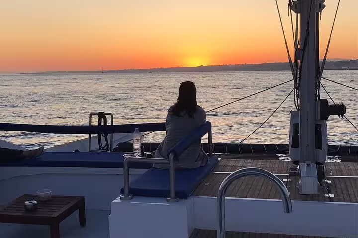 Relaxing sunset view from the deck of catamaran Vertigo during a private sailing tour on Lisbon's tranquil waters.