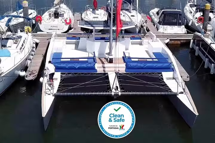 Spacious sailing catamaran Vertigo docked in Lisbon marina, featuring clean and safe certification for up to 18 passengers.