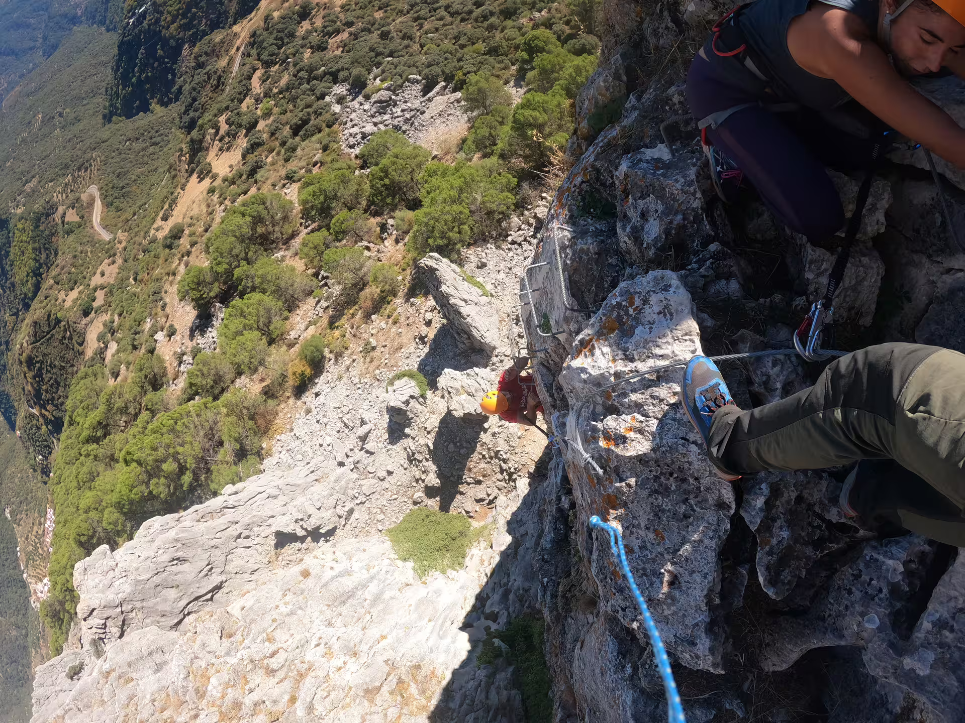 Climbers navigate a steep rocky ascent on Via Ferrata Benadalid, surrounded by stunning Costa del Sol landscapes.