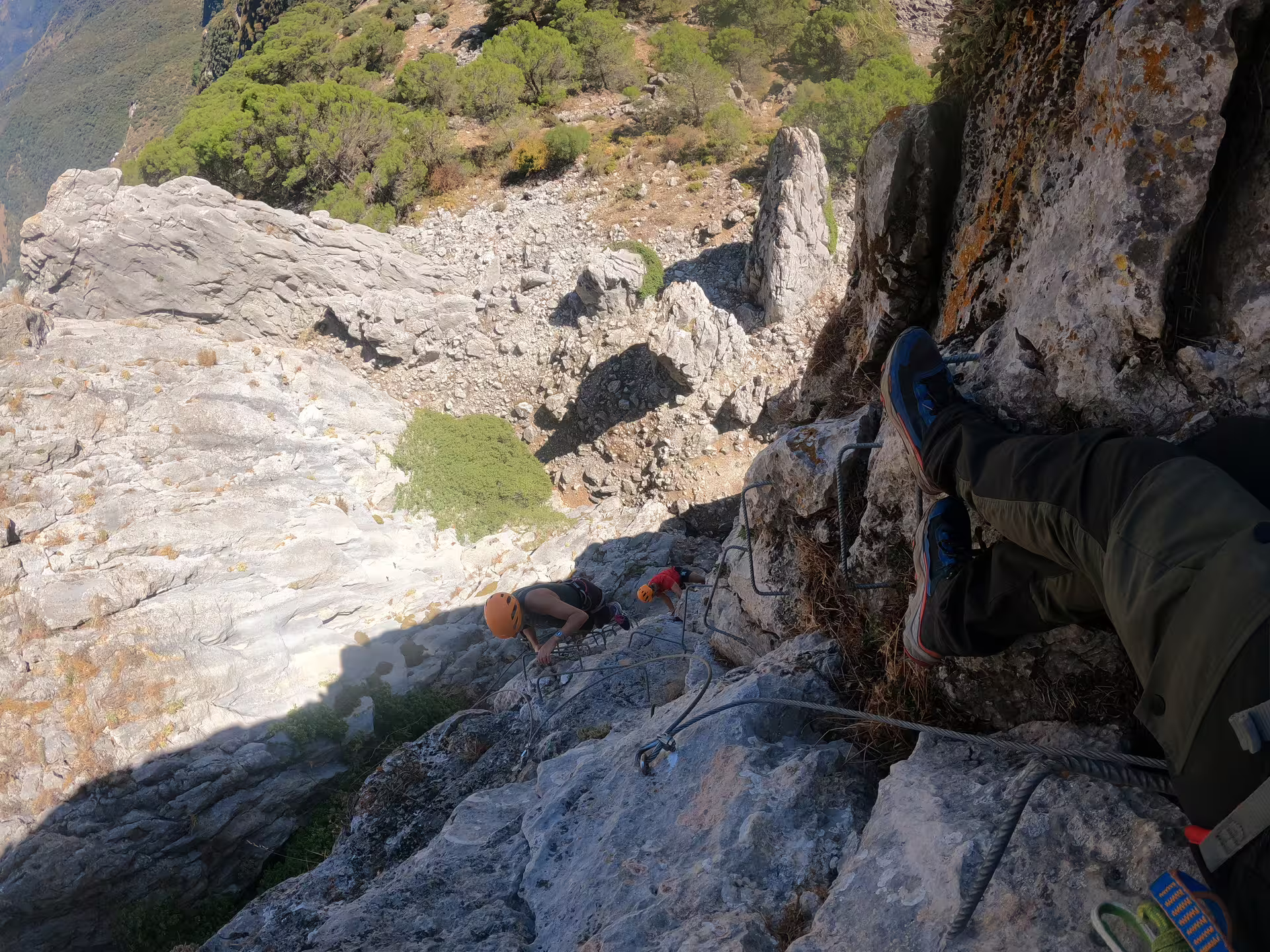 Climbers tackle a steep rock face on Via Ferrata Benadalid, offering stunning views of Costa del Sol's rugged landscape.