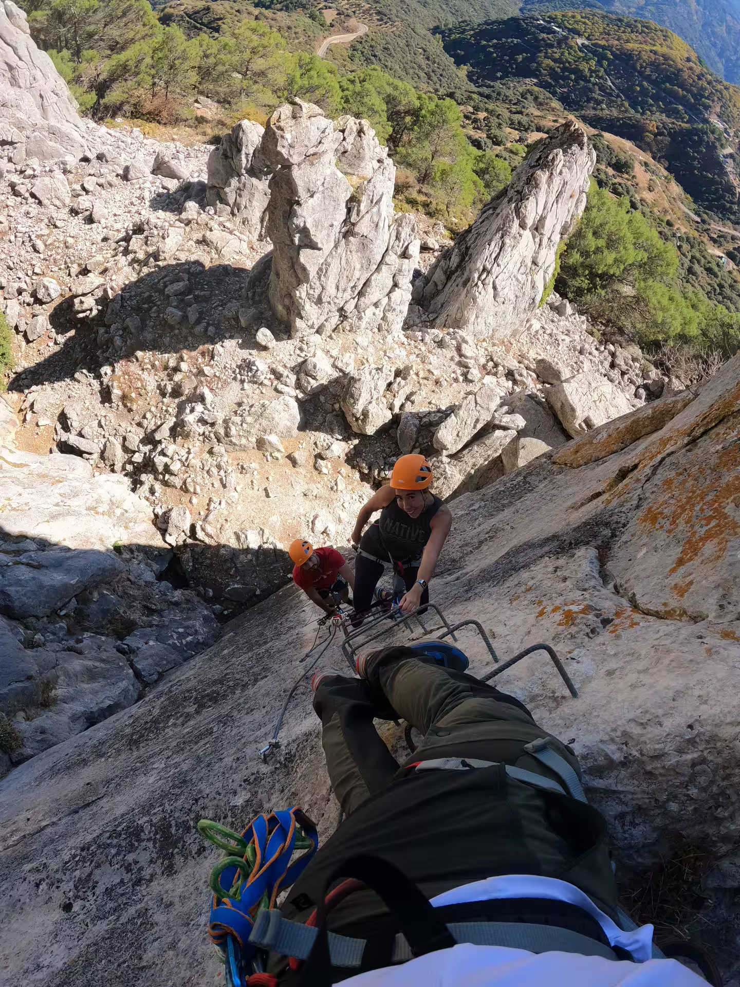 Climbers on Via Ferrata Benadalid navigate challenging vertical rock face with stunning Costa del Sol views.