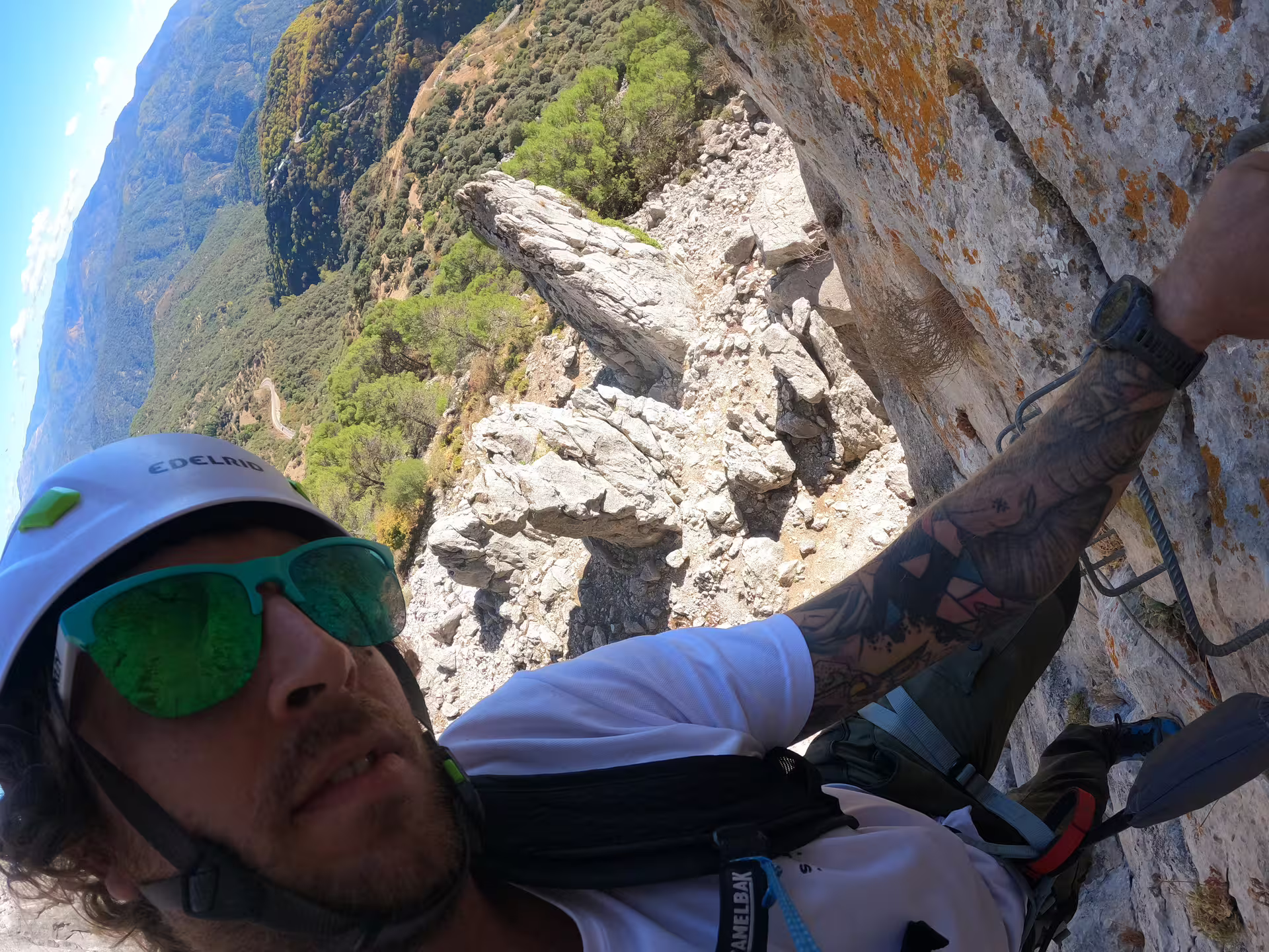 Adventurer climbs Via Ferrata Benadalid, offering stunning views of Costa del Sol's rugged terrain and lush landscapes.