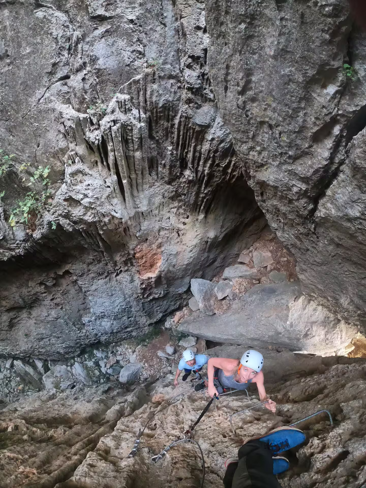 Climber ascending narrow rocky crevice on Via Ferrata route in Benalauría, Costa del Sol, Spain.
