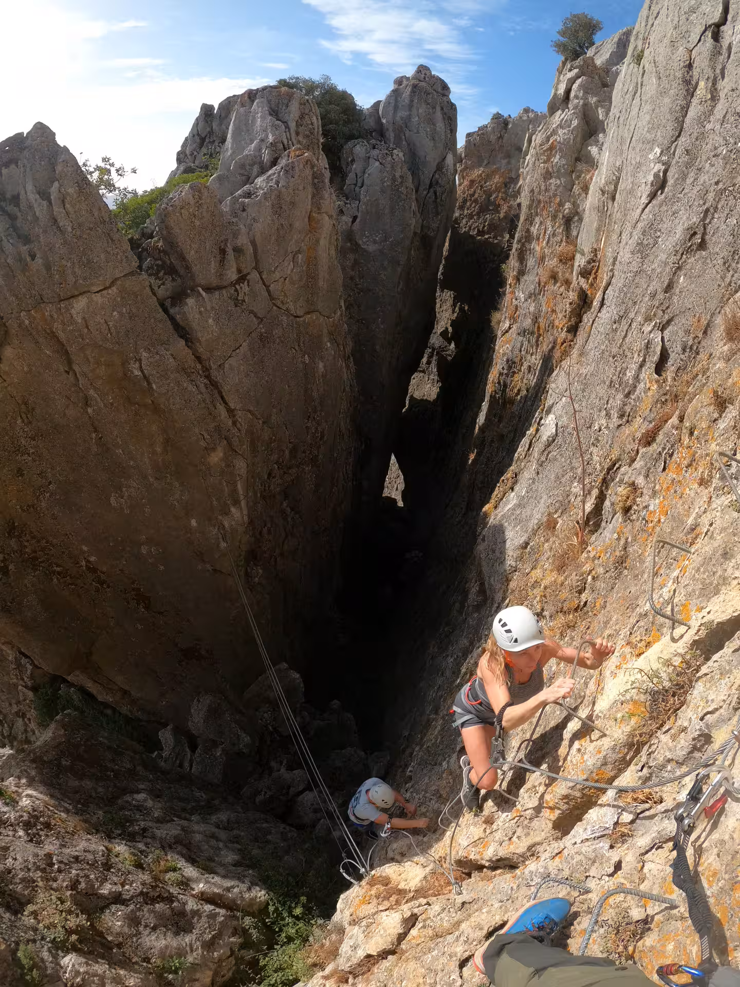 Adventurers scaling a rocky cliff during a thrilling Via Ferrata experience in Benalauría, Costa del Sol.