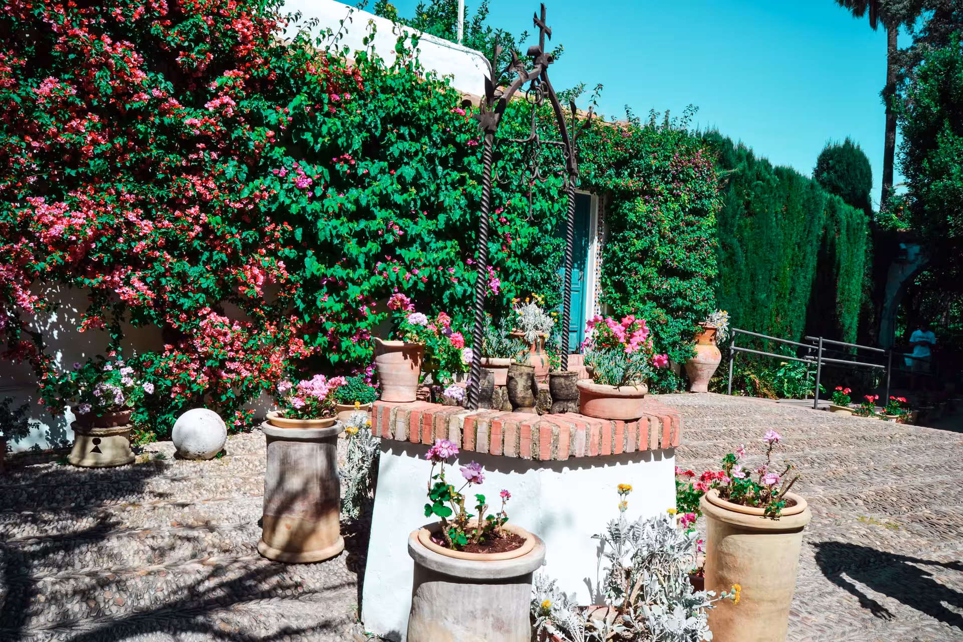 Charming Viana Palace courtyard adorned with colorful climbing flowers and rustic terracotta pots in Cordoba.