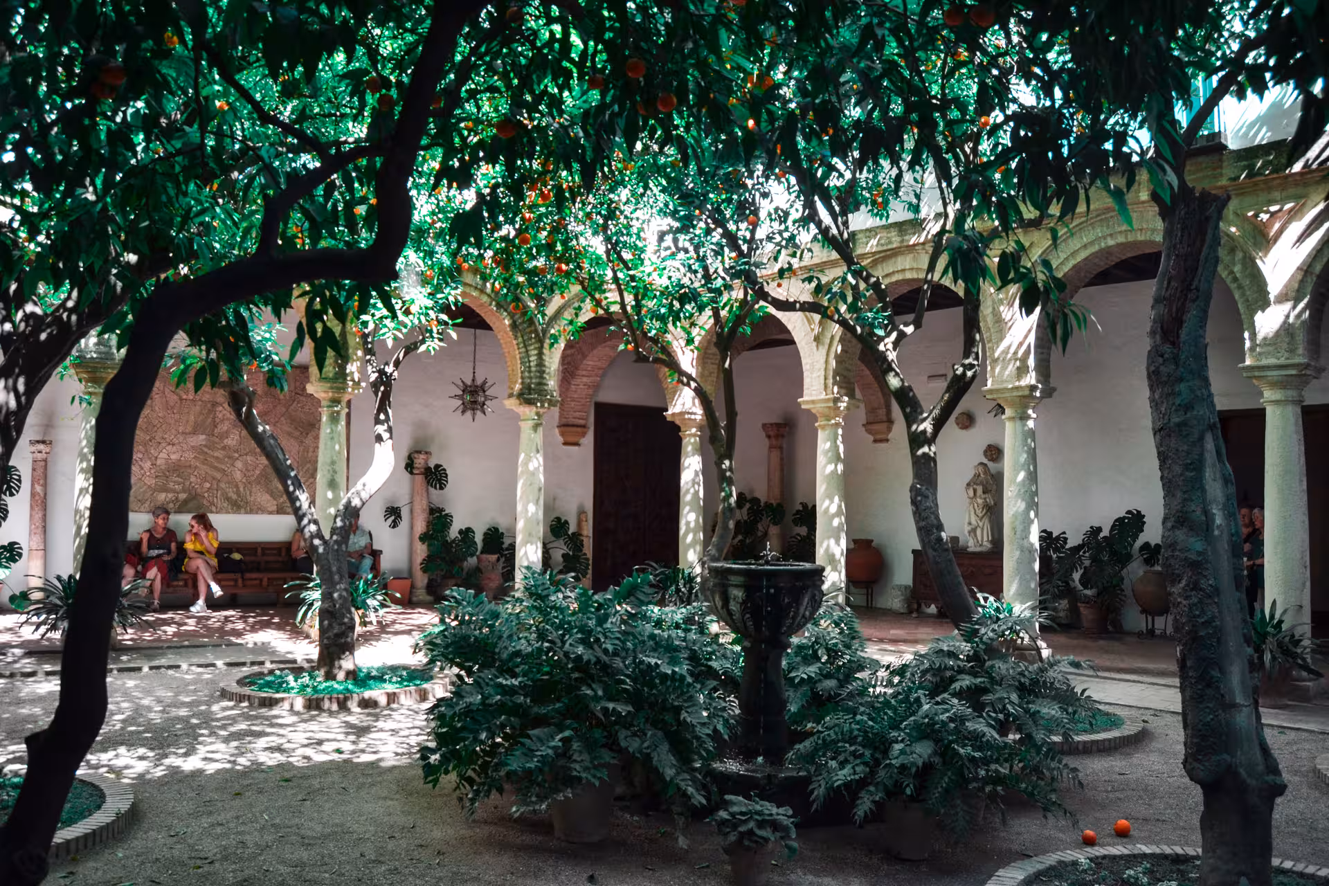 Serene Viana Palace courtyard with orange trees, fountain, and arches, perfect for guided tours.