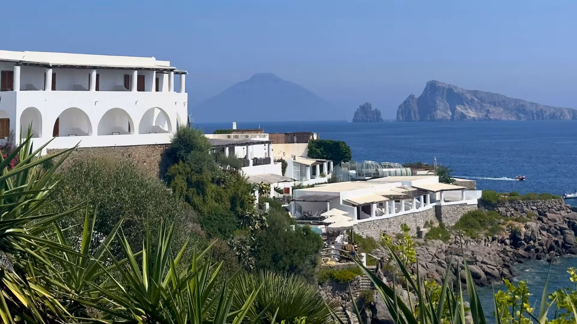 Picturesque view of white Mediterranean architecture with distant volcanic islands in the Aeolian Sea.