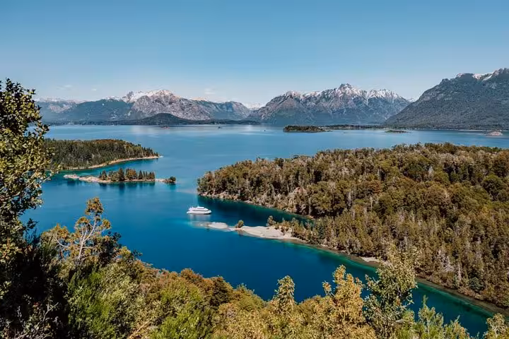 Panoramic view of Victoria Island’s turquoise waters, lush forests, and distant snow-capped mountains.