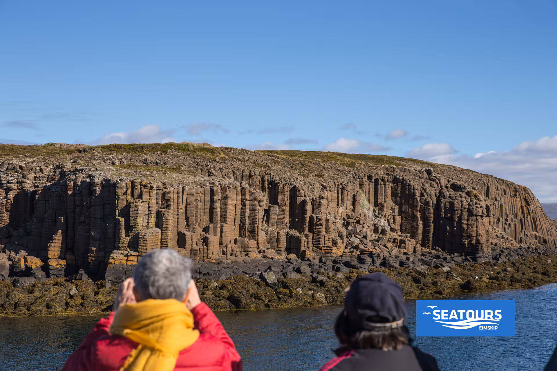 Guests admire Iceland’s basalt sea cliffs on the Viking Sushi Tour boat cruise with local seafood tasting