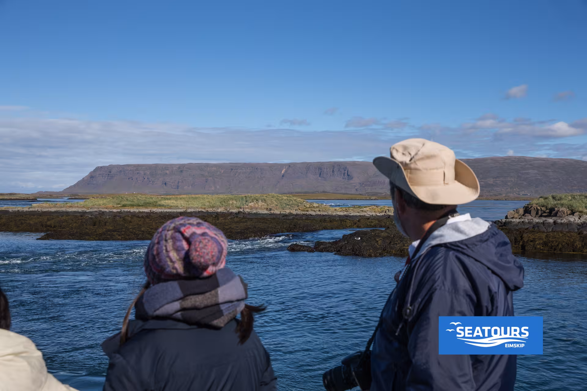 Travelers watch Iceland’s coastal waters from the Viking Sushi Tour boat, pairing scenic views with sushi tasting