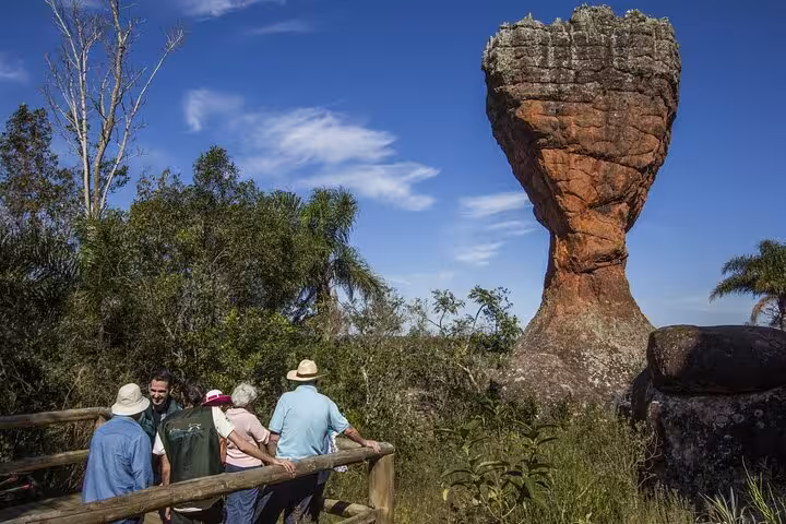 Visitors admire the unique rock formations of Vila Velha State Park on a sunny day, showcasing natural beauty and adventure.